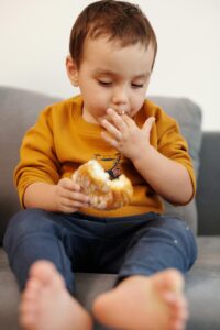 criança comendo alimento ultra processado